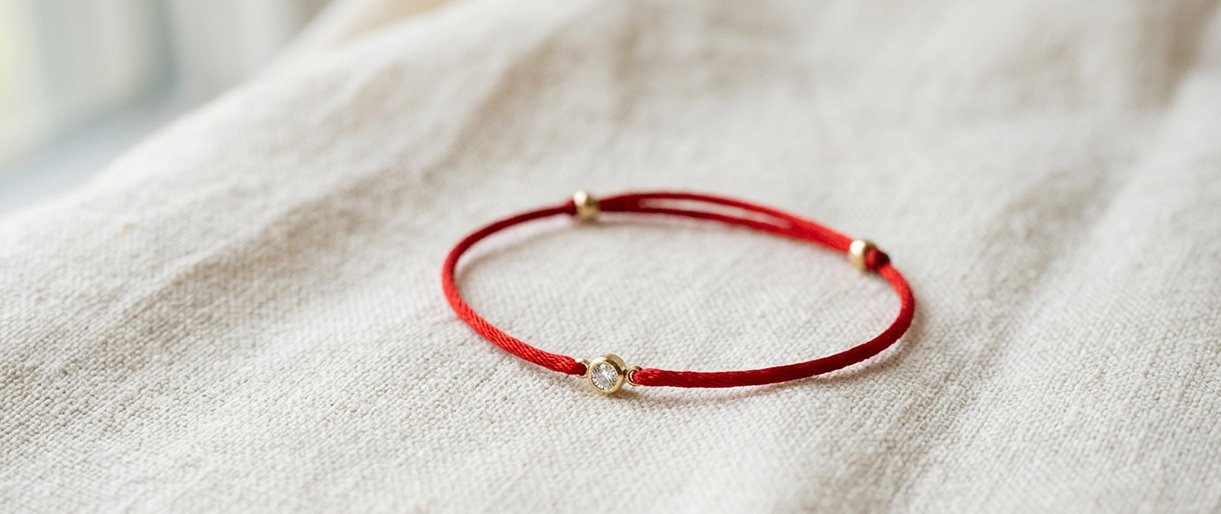 Raudono siūlo apyrankė su deimantu ir jos populiarumas